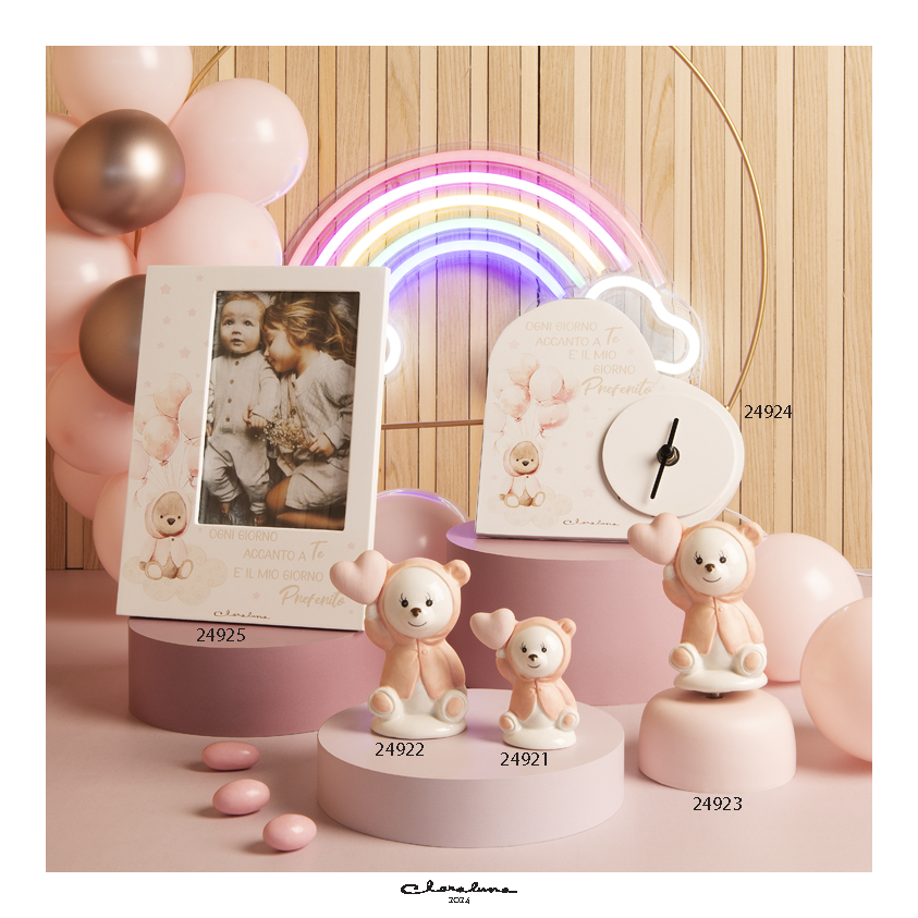 Bomboniera Claraluna delizioso orsetto in porcellana bianca lucida che con cappottino rosa e palloncino a forma di cuore in mano. 24922